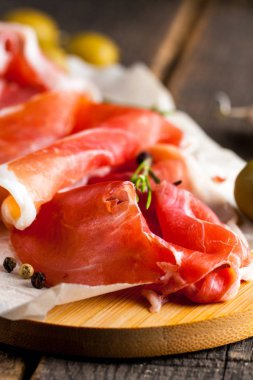 prosciutto ile karışık zeytin ve ahşap kesme tahtası üzerinde kırmızı biber ince dilim closeup
