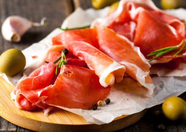 prosciutto ile karışık zeytin ve ahşap kesme tahtası üzerinde kırmızı biber ince dilim closeup