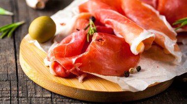 prosciutto ile karışık zeytin ve ahşap kesme tahtası üzerinde kırmızı biber ince dilim closeup