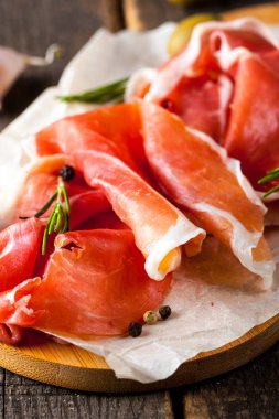 prosciutto ile karışık zeytin ve ahşap kesme tahtası üzerinde kırmızı biber ince dilim closeup