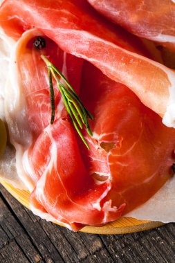 prosciutto ile karışık zeytin ve ahşap kesme tahtası üzerinde kırmızı biber ince dilim closeup