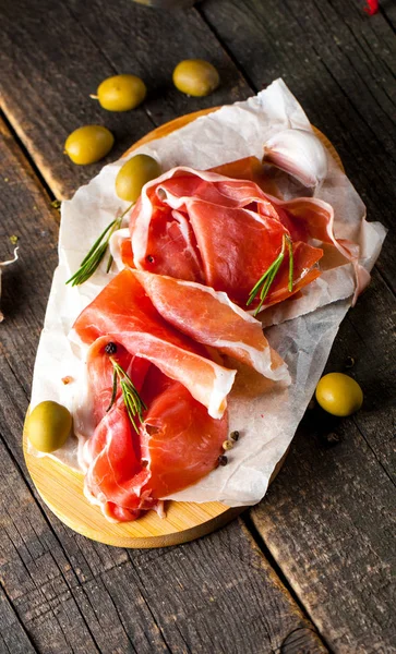 Closeup Thin Slices Prosciutto Mixed Olives Paprika Wooden Cutting Board — Stock Photo, Image