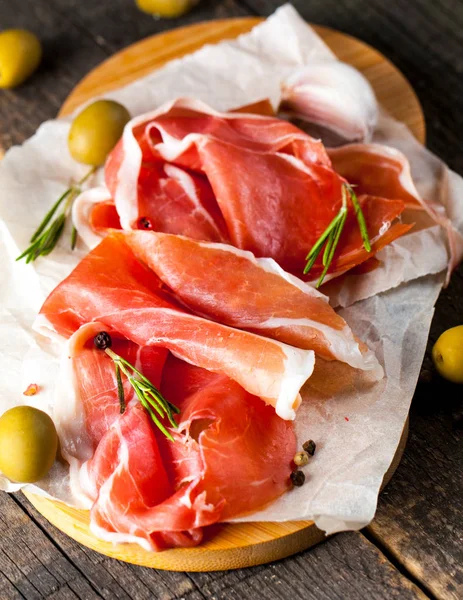 prosciutto ile karışık zeytin ve ahşap kesme tahtası üzerinde kırmızı biber ince dilim closeup
