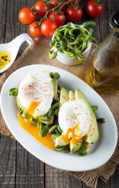 Avokado tost, kiraz domates ahşap arka plan üzerinde. Kahvaltı tost avokado, Vejetaryen gıda, sağlıklı beslenme kavramı ile. Avokado ve haşlanmış yumurta ile sağlıklı sandviç.