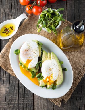 Avokado tost, kiraz domates ahşap arka plan üzerinde. Kahvaltı tost avokado, Vejetaryen gıda, sağlıklı beslenme kavramı ile. Avokado ve haşlanmış yumurta ile sağlıklı sandviç.