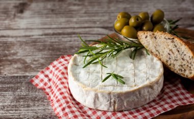 Brie peyniri. Camembert peyniri. Taze Brie peyniri ve tahtadan bir dilim fındık, bal ve yaprakla. İtalyan, Fransız peyniri.