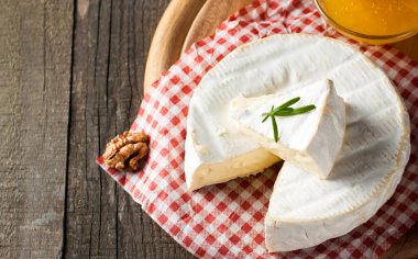 Brie peyniri. Camembert peyniri. Taze Brie peyniri ve tahtadan bir dilim fındık, bal ve yaprakla. İtalyan, Fransız peyniri.