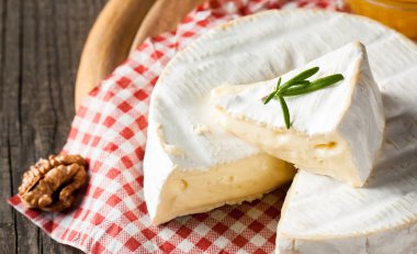 Brie peyniri. Camembert peyniri. Taze Brie peyniri ve tahtadan bir dilim fındık, bal ve yaprakla. İtalyan, Fransız peyniri.