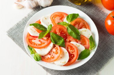 Caprese salatası olgun domates, fesleğen, buffalo mozzarella peyniri ile yakın çekim fotoğraf. İtalyan ve Akdeniz gıda kavramı. Taze ve sağlıklı organik yemek. Starter ve antipasti. 