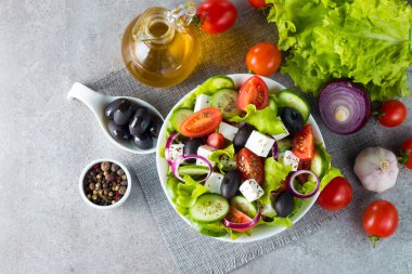 Kiraz domates, ruccola, roka, beyaz peynir, zeytin, salatalık, soğan ve baharat taze Yunan salatası yaptı. Sezar salatası ahşap arka plan üzerinde beyaz bir kase. Sağlıklı organik beslenme gıda kavramı.