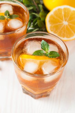 Narenciye limonata yenileniyor, içki yaz. Buzlu çay taze limon ve nane ahşap arka plan üzerinde. Ferahlık içecek konsepti.