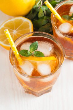 Narenciye limonata yenileniyor, içki yaz. Buzlu çay taze limon ve nane ahşap arka plan üzerinde. Ferahlık içecek konsepti.