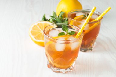 Narenciye limonata yenileniyor, içki yaz. Buzlu çay taze limon ve nane ahşap arka plan üzerinde. Ferahlık içecek konsepti.