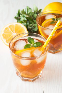 Narenciye limonata yenileniyor, içki yaz. Buzlu çay taze limon ve nane ahşap arka plan üzerinde. Ferahlık içecek konsepti.