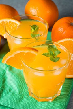 Ahşap ve taş zemin üzerine portakal meyve ile portakal suyu bir bardak close-up. Vitamin ve mineraller. Sağlıklı içki ve içecek konsepti.