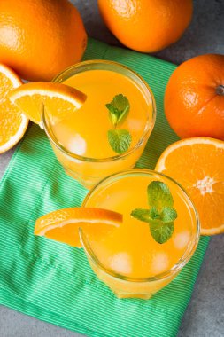 Ahşap ve taş zemin üzerine portakal meyve ile portakal suyu bir bardak close-up. Vitamin ve mineraller. Sağlıklı içki ve içecek konsepti.