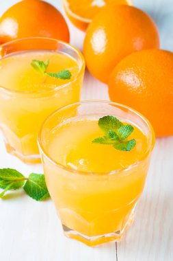 Ahşap ve taş zemin üzerine portakal meyve ile portakal suyu bir bardak close-up. Vitamin ve mineraller. Sağlıklı içki ve içecek konsepti.