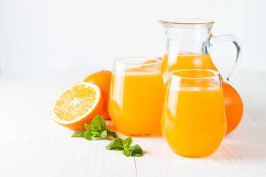 Ahşap ve taş zemin üzerine portakal meyve ile portakal suyu bir bardak close-up. Vitamin ve mineraller. Sağlıklı içki ve içecek konsepti.