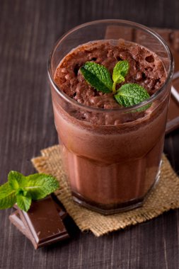 Çikolata, kahve, süt, muz sallamak ahşap arka plan üzerinde. Nane ile güler yüzlü. Milkshake. Protein diyeti. Sağlıklı yiyecek ve içecek konsepti.