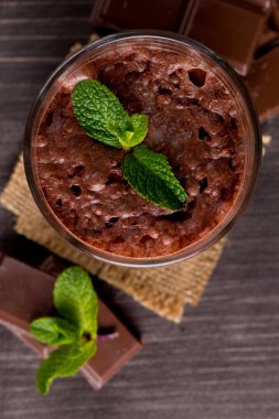 Çikolata, kahve, süt, muz sallamak ahşap arka plan üzerinde. Nane ile güler yüzlü. Milkshake. Protein diyeti. Sağlıklı yiyecek ve içecek konsepti.