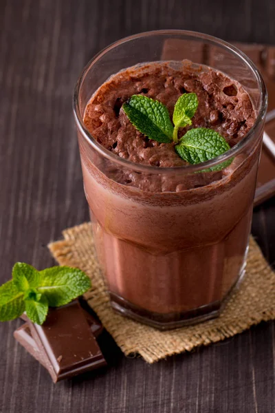 Çikolata, kahve, süt, muz sallamak ahşap arka plan üzerinde. Nane ile güler yüzlü. Milkshake. Protein diyeti. Sağlıklı yiyecek ve içecek konsepti.