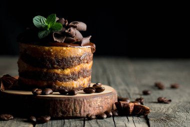 Çikolatalı kek siyah slatter kurulu ile nane, kahve çekirdekleri koyu arka plan, closeup fotoğraf üzerinde. Taze, lezzetli tatlı gıda kavramı. 