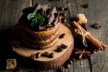 Çikolatalı kek siyah slatter kurulu ile nane, kahve çekirdekleri koyu arka plan, closeup fotoğraf üzerinde. Taze, lezzetli tatlı gıda kavramı. 