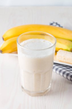 Taze yapılmış çikolata muz Smoothie ahşap bir masa üzerinde. Seçici odak. Bademli muzlu süt. Protein diyeti. Sağlıklı yiyecek ve içecek konsepti.