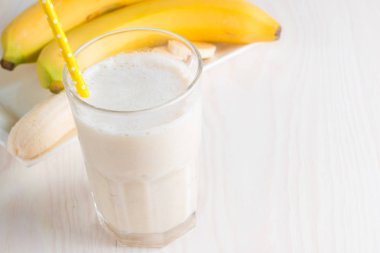 Taze yapılmış çikolata muz Smoothie ahşap bir masa üzerinde. Seçici odak. Bademli muzlu süt. Protein diyeti. Sağlıklı yiyecek ve içecek konsepti.
