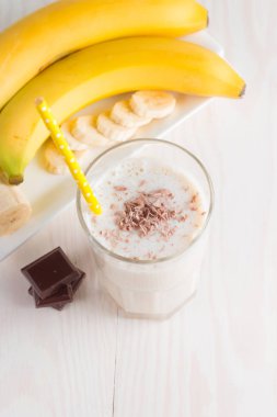 Taze yapılmış çikolata muz Smoothie ahşap bir masa üzerinde. Seçici odak. Bademli muzlu süt. Protein diyeti. Sağlıklı yiyecek ve içecek konsepti.