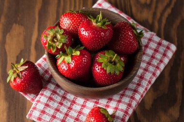 Ahşap kase taze doğal çilek. Sağlıklı vegan gıda konsepti. Yaz eko meyve ve sebzeler.