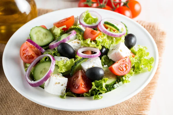 新鲜的希腊沙拉 由樱桃西红柿 Ruccola 芝麻菜 洋葱和香料制成 凯撒沙拉在一个白色的碗在木质背景 健康有机饮食食品概念 — 图库照片