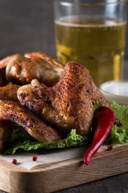 Yakın çekim fotoğraf Barbekü tavuk kanatlı patates ve bira. Barbekü soslar, ketçap, mayonez etli. Hızlı ve abur cubur kavramı. 