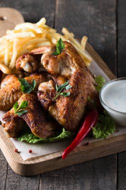 Yakın çekim fotoğraf Barbekü tavuk kanatlı patates ve bira. Barbekü soslar, ketçap, mayonez etli. Hızlı ve abur cubur kavramı. 