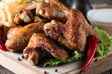 Yakın çekim fotoğraf Barbekü tavuk kanatlı patates ve bira. Barbekü soslar, ketçap, mayonez etli. Hızlı ve abur cubur kavramı. 