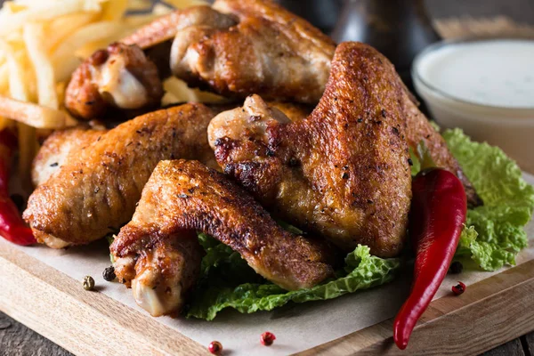 Yakın çekim fotoğraf Barbekü tavuk kanatlı patates ve bira. Barbekü soslar, ketçap, mayonez etli. Hızlı ve abur cubur kavramı. 