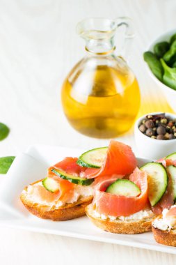 Somon, salatalık ve krem peynir bruschetta. İtalyan tapas antipasti sebzeler, otlar ve ızgara ciabatta ve baget ekmek üzerine. Sandviç.