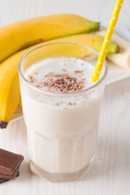 Taze yapılmış çikolata muz Smoothie ahşap bir masa üzerinde. Seçici odak. Bademli muzlu süt. Protein diyeti. Sağlıklı yiyecek ve içecek konsepti.