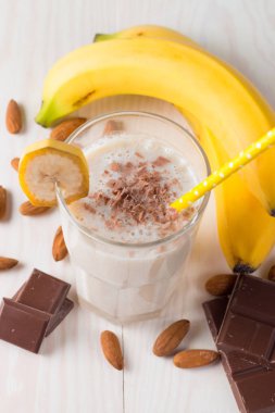 Taze yapılmış çikolata muz Smoothie ahşap bir masa üzerinde. Seçici odak. Bademli muzlu süt. Protein diyeti. Sağlıklı yiyecek ve içecek konsepti.