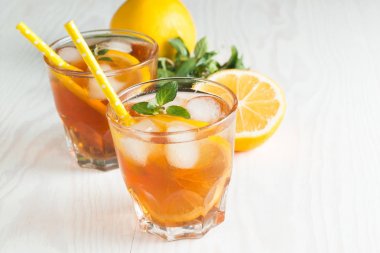 Narenciye limonata yenileniyor, içki yaz. Buzlu çay taze limon ve nane ahşap arka plan üzerinde. Ferahlık içecek konsepti.