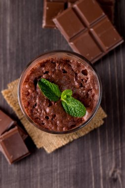 Çikolata, kahve, süt, muz sallamak ahşap arka plan üzerinde. Nane ile güler yüzlü. Milkshake. Protein diyeti. Sağlıklı yiyecek ve içecek konsepti.