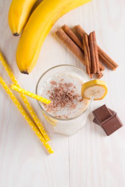 Taze yapılmış çikolata muz Smoothie ahşap bir masa üzerinde. Seçici odak. Bademli muzlu süt. Protein diyeti. Sağlıklı yiyecek ve içecek konsepti.