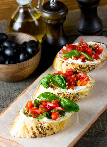 新鲜的西红柿和奶酪制成 Bruschetta 意大利小吃 开胃小菜蔬菜 草药和油在烤 Ciabatta 和法式面包 — 图库照片