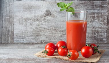 Bir bardak domates suyu ahşap Sivas'tan zemin üzerine sebzeli close-up. Vitamin ve mineraller. Sağlıklı içecek konsepti.