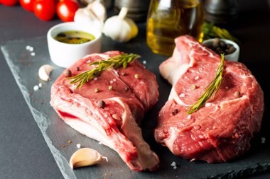 Çiğ et, biftek ve domuz eti, pirzola, biberiye, biber ve tuz. Tuzlu ve baharatlı mermer sığır pirzolası.