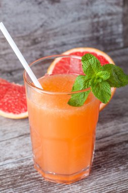 Ahşap masa yakın çekim meyve suyu ile olgun greyfurt bir bardak