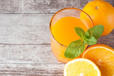 Ahşap ve taş zemin üzerine portakal meyve ile portakal suyu bir bardak close-up. Vitamin ve mineraller. Sağlıklı içki ve içecek konsepti.