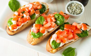 Domates ve peynirli taze yapılmış bruschetta. İtalyan tapas antipasti sebzeler, otlar ve ızgara ciabatta ve baget ekmek üzerine. Sandviç.