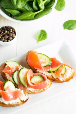 Somon, salatalık ve krem peynir bruschetta. İtalyan tapas antipasti sebzeler, otlar ve ızgara ciabatta ve baget ekmek üzerine. Sandviç.