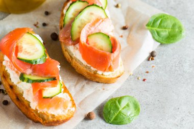 Somon, salatalık ve krem peynir bruschetta. İtalyan tapas antipasti sebzeler, otlar ve ızgara ciabatta ve baget ekmek üzerine. Sandviç.